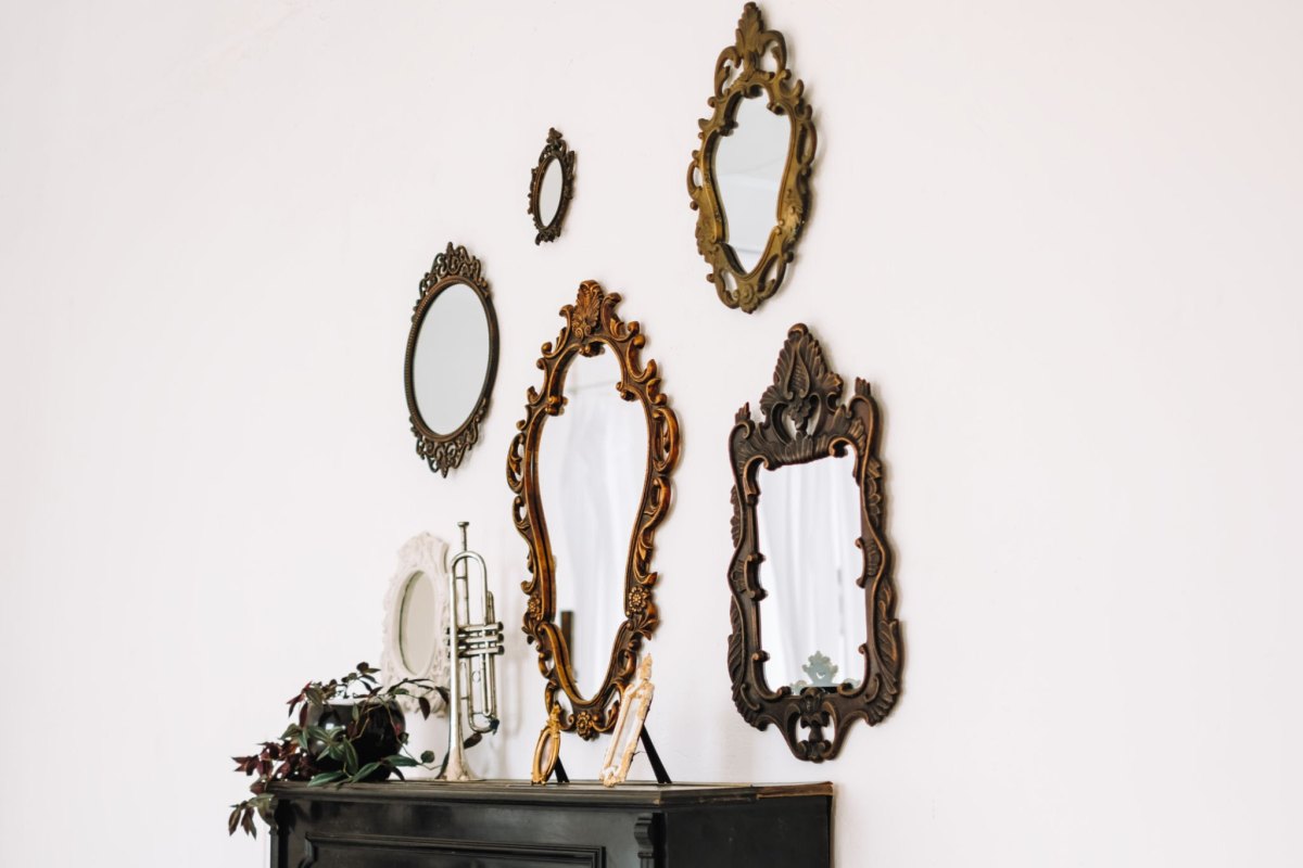 Antique vintage mirrors arranged on a white wall