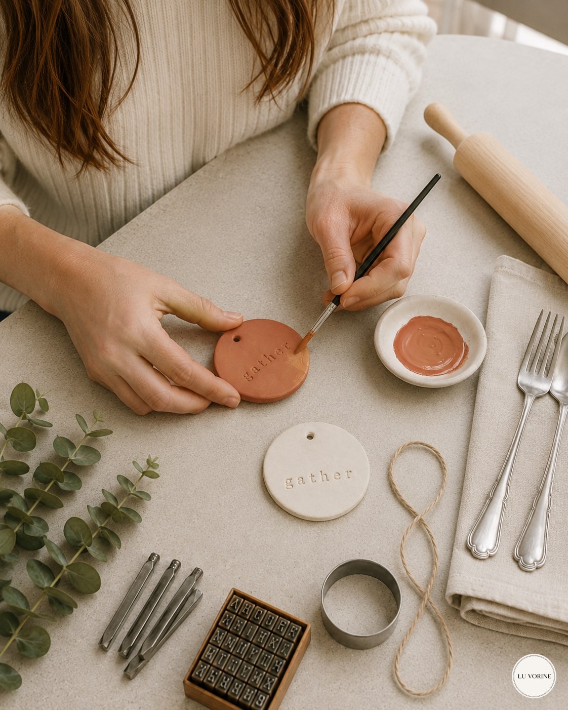 Painting a dried clay napkin ring tag terracotta with a small brush