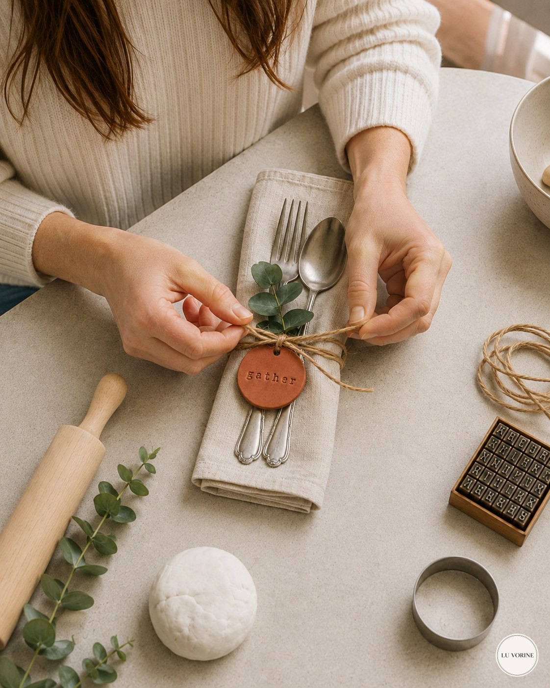 Tying a clay napkin ring tag with twine around a folded linen napkin