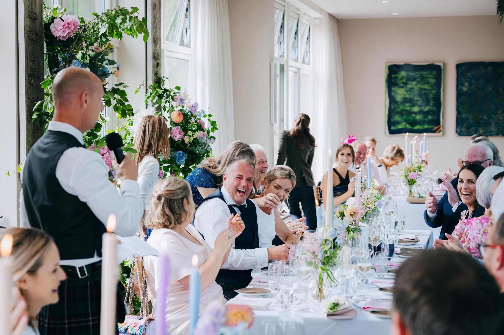 Wedding guests laughing during toast