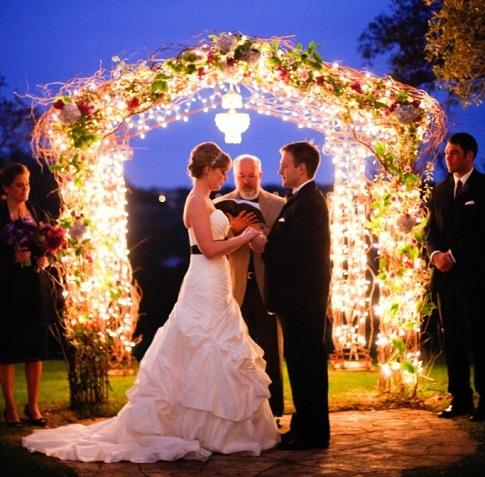 Fairy lights glowing on wedding arch