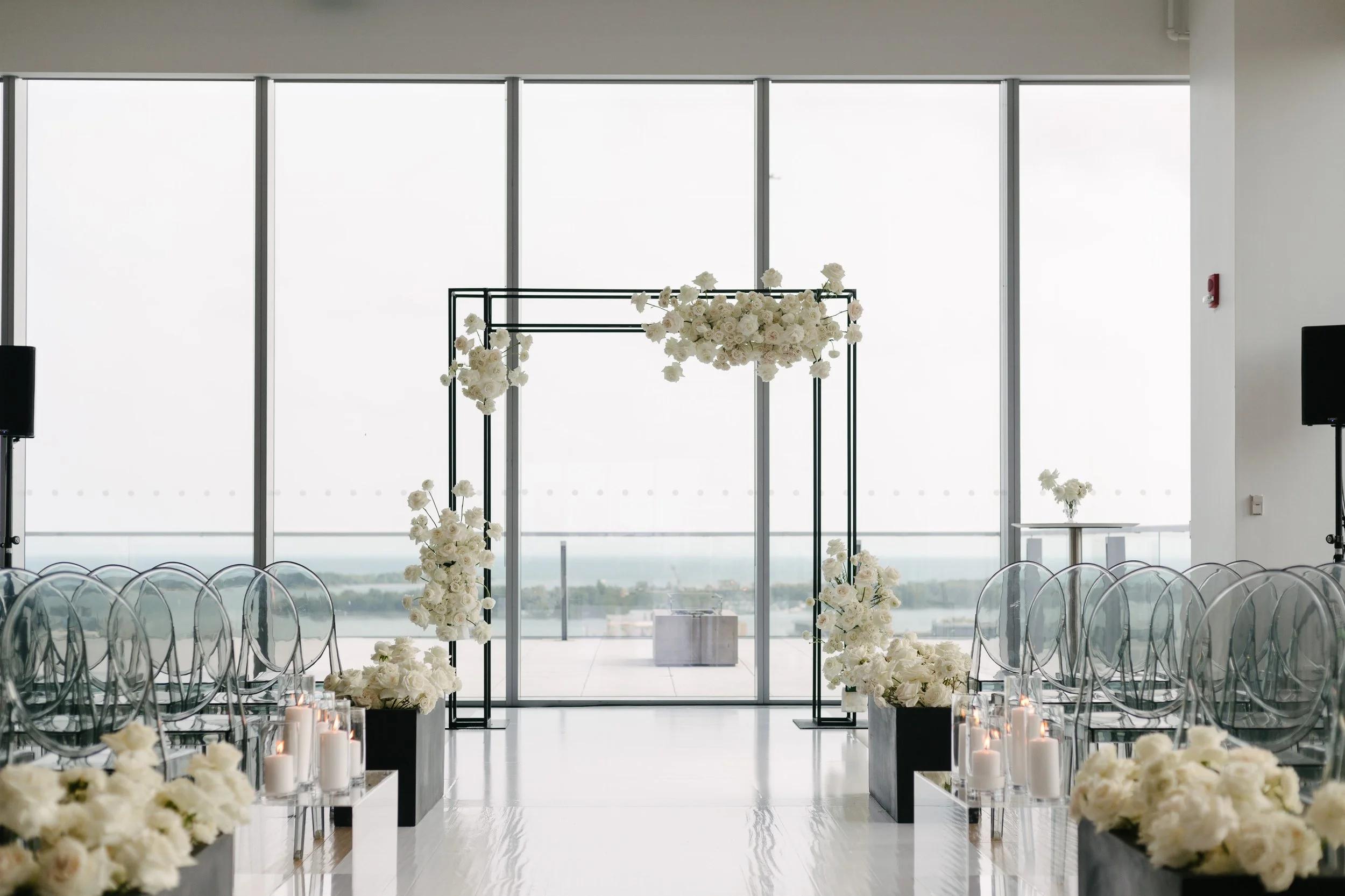 Minimal white wedding arch at elegant ceremony