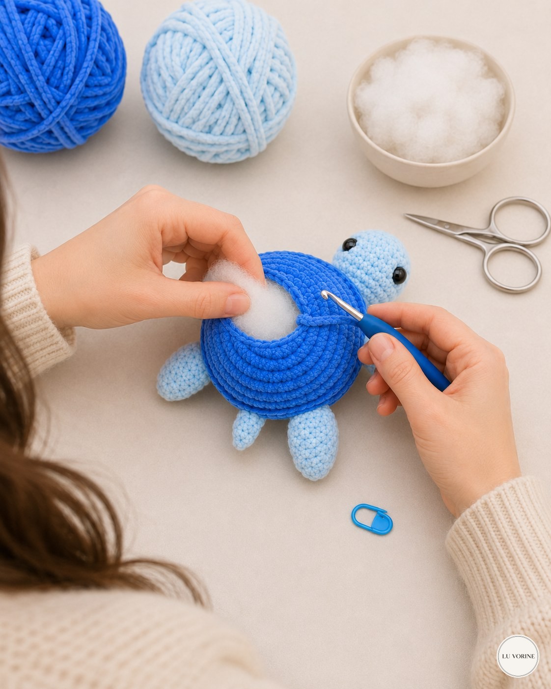 Pushing stuffing into the shell opening by hand while finishing the no-sew plush turtle