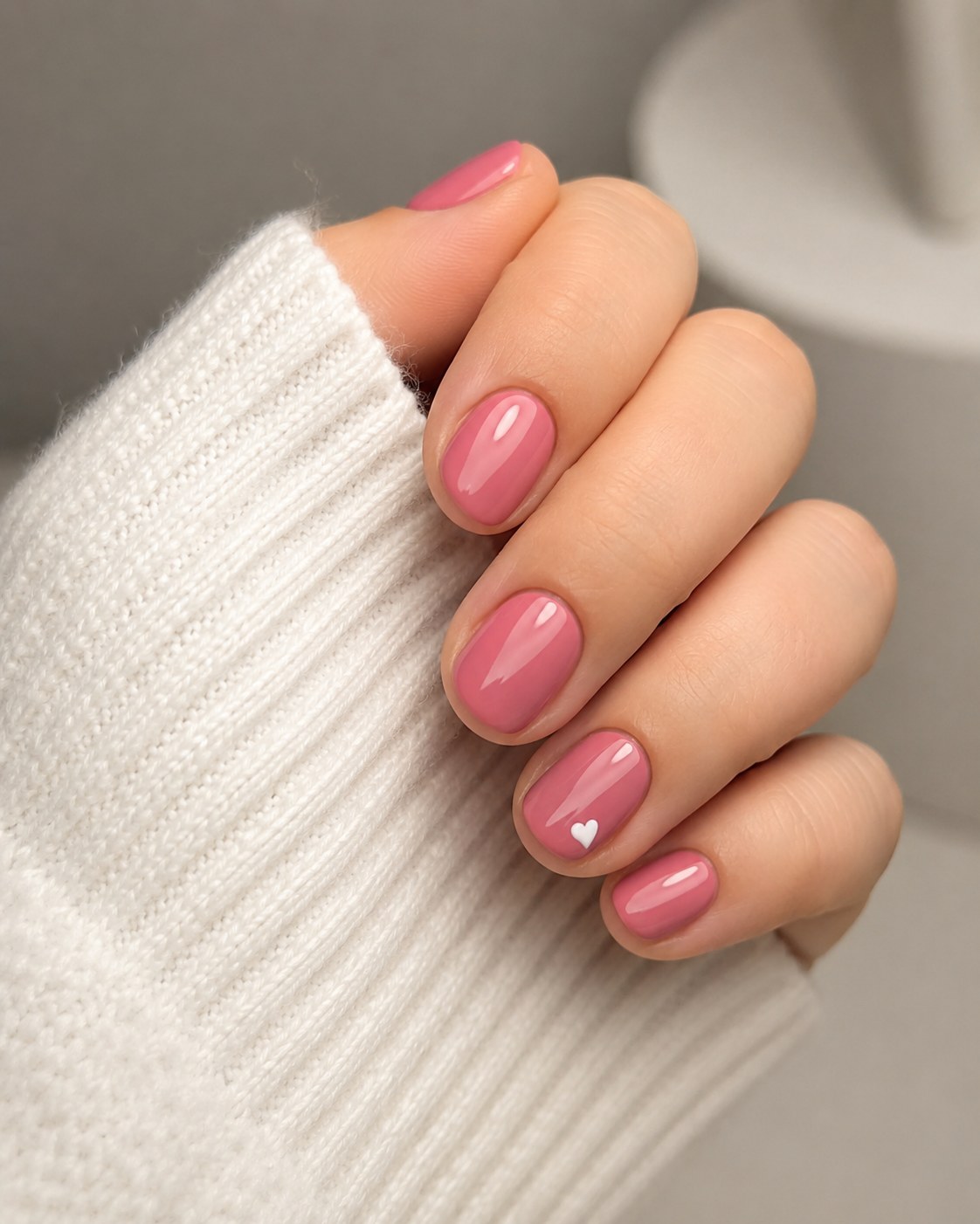 Short shellac nails in dusty rose with a hand-painted white heart accent on the ring finger.